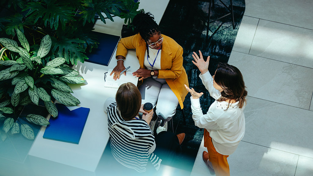 Overhead view of female colleagues discussing in modern office
