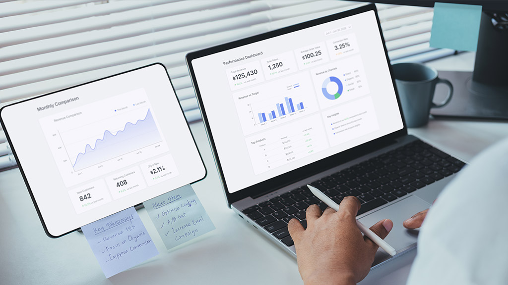Laptop and tablet on a desk showing a performance analytics dashboard